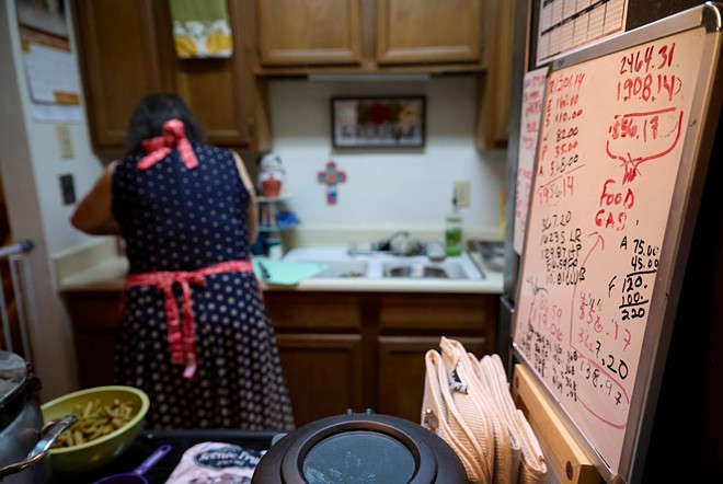 A whiteboard tracking monthly expenses can be seen inside Mary Ann Estrella’s kitchen as she prepares homemade dog food inside her apartment in Midland on April 20. At the time, Estrella estimated that $138.97 would be leftover in her budget at the end of April. - Texas Tribune / Reilly Strand