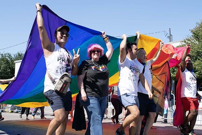 Marchers carry a section of the Gilbert Baker Rainbow Flag, created in 2003 to stretch from the Gulf of Mexico to the Atlantic Ocean. - Courtesy Photo / San Antonio LGBTQ+ Chamber of Commerce