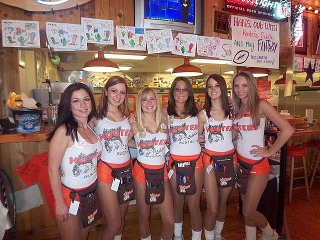 Staffers at a Hooters store show off the skimpy attire the chain is known for. - Wikimedia Commons / MarkScottAustinTX