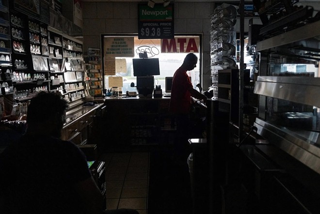 Seby Godinho and Jack Souza operate a convenience store without power in Oyster Creek after Hurricane Beryl on July 9. – Reuters / Adrees Latif