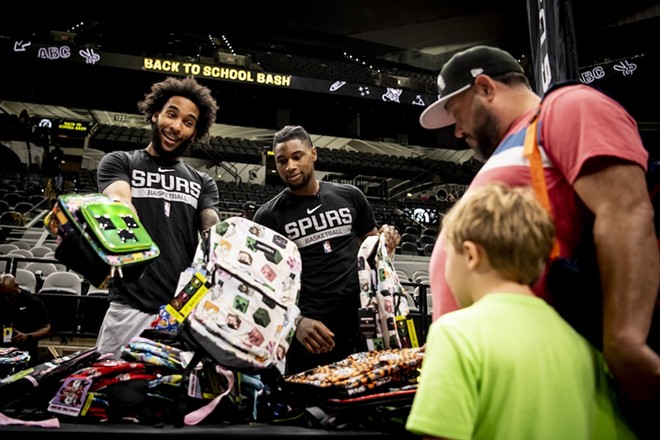 Spurs players hand out backpacks at last year's Back to School Bash. - Courtesy of Spurs Sports & Entertainment