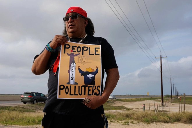 Juan Mancias, tribal chair of the Carrizo Comecrudo Tribe of Texas, holds a sign in front of the gates leading to the site where NextDecade's Rio Grande LNG has begun preparing land for a LNG terminal near Port Isabel, on April 1, 2023. - Texas Tribute / Michael Gonzalez