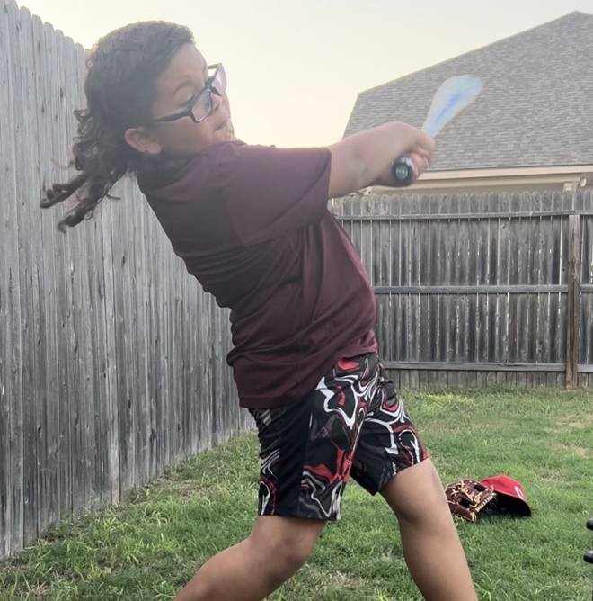 Judson ISD student Avery Quiroz rocks the locks while swinging at baseballs in his backyard. - MulletChamp.com / Avery Quiroz