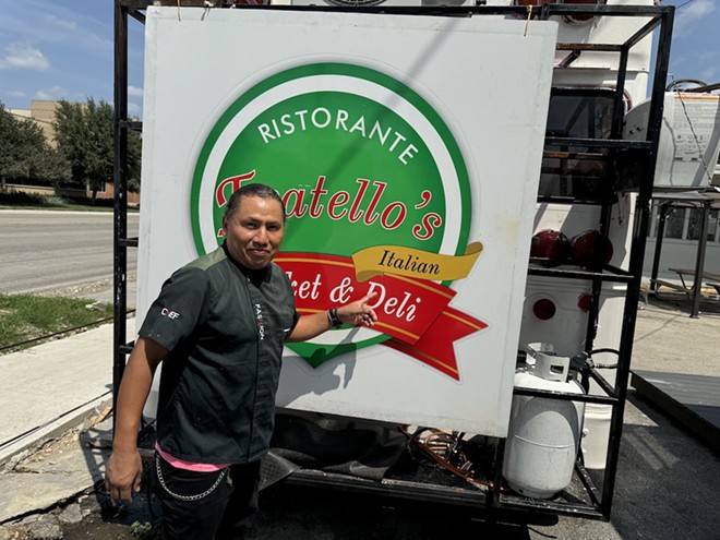 Owner Filiberto Torres poses in front of the sign from the original Fratello's, which he now displays on the back of his Broadway food truck. - Stephanie Koithan