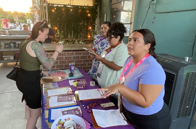 Registrars sign up voters at a table in the Paper Tiger's beer garden. - Sanford Nowlin