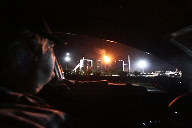 Mike Cerny surveys an oil storage site across the street from his Karnes County home in 2013 - Michael Barajas