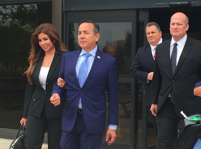 State Sen. Carlos Uresti leaves San Antonio's federal courthouse, followed by attorney Mikal Watts, after his May indictment. - ALEX ZIELINSKI