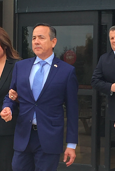 State Sen. Carlos Uresti leaves San Antonio's federal courthouse, followed by attorney Mkal Watts, after his May indictment.