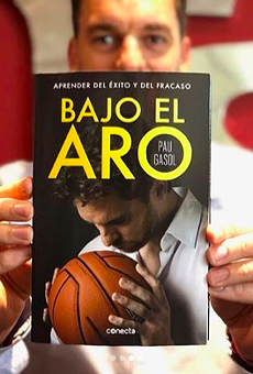 Pau Gasol shows off a copy of his autobiography, Bajo El Aro.