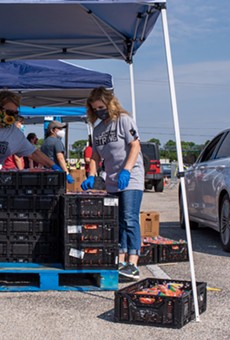 Volunteers unload pallets at San Antonio Food Bank distribution.