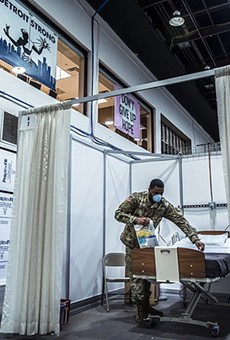 A solider helps prepare a room in a temporary hospital facility in Detroit to handle overflow COVID-19 patients.