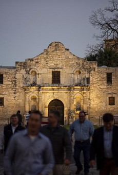 Visitors cross the street away from the Alamo in San Antonio.