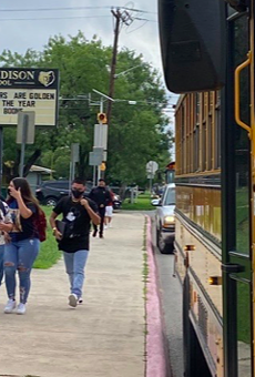 Masked students approach Thomas Edison High School.