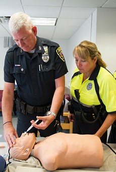 An Boston University police officer demonstrates how to administer naloxone.