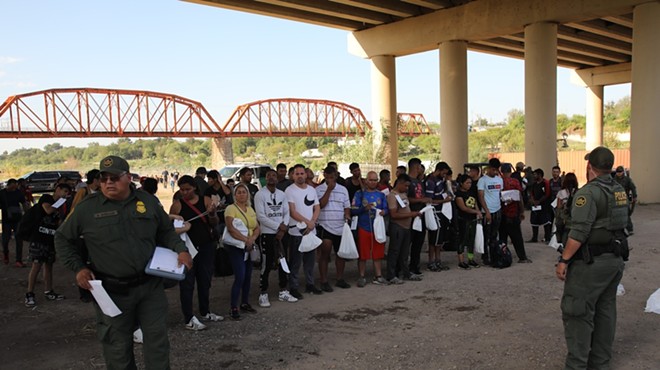 Border Patrol agents take a group of migrants seeking U.S. asylum into custody under the International Bridge in Eagle Pass last fall.
