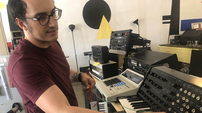 Luis Faraklas Trevino shows off a vintage synthesizer on the floor of Output Audio, which also includes a recording studio.
