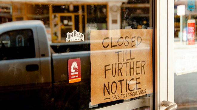 A homemade closure sign hangs in the window of a downtown San Antonio business.