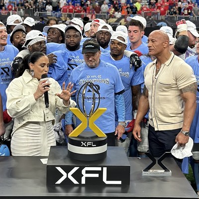 XFL League owners Dany Garcia (left) and Dwayne 'The Rock' Johnson (right) award the championship trophy to the Arlington Renegades at the Alamodome on May 13.